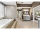 Bright bathroom showcasing a soaking tub, gray tiled walls, and a modern vanity at 16242 Rambling Rd, Odessa, FL 33556