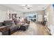 Bright living room featuring wood-look tile, plush furniture, and sliding glass doors to the outdoor space at 16242 Rambling Rd, Odessa, FL 33556