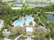 Aerial view of community amenities including pools and ponds surrounded by mature trees at 1767 Tonka Ter, Wesley Chapel, FL 33543