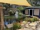 Landscaped backyard showcasing a tranquil pond, stone accents, plants and outdoor storage shed at 2005 Jackson N St, St Petersburg, FL 33704