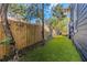 Well-maintained backyard featuring manicured turf, wooden privacy fence, and partial view of deck at 2005 Jackson N St, St Petersburg, FL 33704