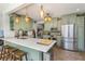 Light green kitchen featuring a large island, stainless steel appliances, and stylish pendant lighting at 2005 Jackson N St, St Petersburg, FL 33704