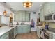 Well-lit kitchen with white counters, light green cabinets, tile flooring, and stainless steel appliances at 2005 Jackson N St, St Petersburg, FL 33704