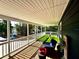 Relax on this covered porch with wood flooring, artificial turf, and outdoor seating at 2005 Jackson N St, St Petersburg, FL 33704