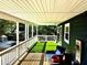 Beautiful covered porch features wooden floors, artificial turf and comfortable outdoor seating at 2005 Jackson N St, St Petersburg, FL 33704