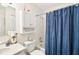 Bathroom includes vanity, toilet, and tub with blue curtain at 2009 Halidom Way, Sun City Center, FL 33573