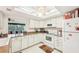 Well-lit kitchen with white cabinets, modern appliances, and a view into the living area at 2009 Halidom Way, Sun City Center, FL 33573