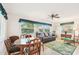 Inviting living room with wood table, dark leather sofa, and tropical-themed rug and decor at 2009 Halidom Way, Sun City Center, FL 33573