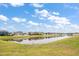 Scenic backyard view of a peaceful lake surrounded by well-maintained homes under a sunny sky at 2011 Hawks View Dr, Ruskin, FL 33570