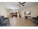 Open-concept living room with tile flooring, ceiling fan, and adjacent kitchen with breakfast bar at 2011 Hawks View Dr, Ruskin, FL 33570