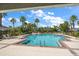 Community pool surrounded by palm trees, lounge chairs, and lush landscaping at 2011 Hawks View Dr, Ruskin, FL 33570