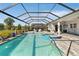 Aerial view of the screened in pool and spa overlooking lush backyard landscaping and gorgeous lake at 2637 Butterfly Jasmine Trl, Sarasota, FL 34240