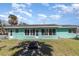 Back exterior of house boasts large windows, a rear entrance, and lush palm trees at 311 Ravenna N St, Nokomis, FL 34275
