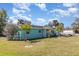 Charming one-story home with light blue exterior, green grass and palm trees at 311 Ravenna N St, Nokomis, FL 34275