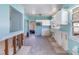 Kitchen with aqua walls and damaged trim with view to the backyard at 311 Ravenna N St, Nokomis, FL 34275