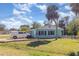 One-story home with light blue exterior, white trim, green grass and palm trees at 311 Ravenna N St, Nokomis, FL 34275