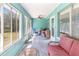 Bright sunroom with ample windows, ceiling fan, and comfortable seating arrangement at 311 Ravenna N St, Nokomis, FL 34275
