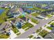 Expansive aerial view of a residential neighborhood with neatly arranged homes, community pond and green spaces at 31399 Penny Surf Loop, Wesley Chapel, FL 33545