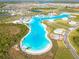Aerial view of the community showcasing the extensive lagoon, beach areas, and recreational facilities for residents at 31399 Penny Surf Loop, Wesley Chapel, FL 33545