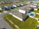 Aerial view showcasing the home's pool and patio, set within a vibrant neighborhood with manicured lawns and streets at 31399 Penny Surf Loop, Wesley Chapel, FL 33545
