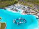 Stunning aerial view of a lagoon with beach, lounge chairs, island and waterpark inflatables at 31399 Penny Surf Loop, Wesley Chapel, FL 33545