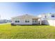 Image of a simple backyard showing the back of the house, lawn, and fence at 31399 Penny Surf Loop, Wesley Chapel, FL 33545