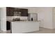 Modern kitchen features granite countertops, stainless steel appliances, island, tile floors, and dark cabinetry at 31399 Penny Surf Loop, Wesley Chapel, FL 33545
