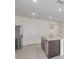 Modern kitchen features an island with granite countertops, stainless steel appliances, and tile floors at 31399 Penny Surf Loop, Wesley Chapel, FL 33545