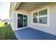 Covered outdoor patio with a large sliding glass door and window provides ample light and easy access to the backyard at 31399 Penny Surf Loop, Wesley Chapel, FL 33545