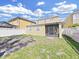 Spacious backyard featuring a screened-in porch and a white fence, perfect for outdoor entertaining at 31730 Spoonflower Cir, Wesley Chapel, FL 33545