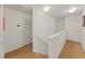 Upstairs hallway with carpeted floor, white walls, doors, and railing at 31730 Spoonflower Cir, Wesley Chapel, FL 33545