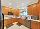 Kitchen with wood cabinets, white countertops, and modern appliances, including hanging pots and pans at 31730 Spoonflower Cir, Wesley Chapel, FL 33545