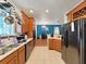Well-equipped kitchen with wood cabinets, modern appliances, and open view to a dining/office area at 31730 Spoonflower Cir, Wesley Chapel, FL 33545