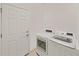 Well-lit laundry area equipped with a washer and dryer next to the entry door at 31730 Spoonflower Cir, Wesley Chapel, FL 33545