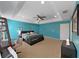 Main bedroom features blue walls, carpeting, a large bed and access to an ensuite bath at 31730 Spoonflower Cir, Wesley Chapel, FL 33545