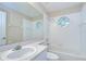A bathroom offers a tub with tile surround, a white vanity and an octagon window at 34907 Double Eagle Ct, Zephyrhills, FL 33541