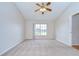 This expansive bedroom features a window and neutral carpeting and trim at 34907 Double Eagle Ct, Zephyrhills, FL 33541