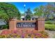 Brick clubhouse sign for Lake Bernadette surrounded by lush landscaping and colorful flowers at 34907 Double Eagle Ct, Zephyrhills, FL 33541