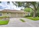 Charming home with a two-car garage, manicured lawn, and mature shade tree offering curb appeal at 34907 Double Eagle Ct, Zephyrhills, FL 33541