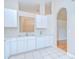 Functional kitchen with white appliances, cabinets, and adjacent arched doorway at 34907 Double Eagle Ct, Zephyrhills, FL 33541