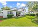 Spacious backyard featuring lush green lawn, mature trees, a covered patio, and meticulously maintained landscaping at 3709 W Horatio St, Tampa, FL 33609