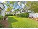 Lush backyard with expansive lawn, mature trees, manicured hedges and flower beds, perfect for outdoor enjoyment at 3709 W Horatio St, Tampa, FL 33609