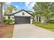 Well-maintained home featuring a landscaped yard, an attached two-car garage, and stylish black and white accents at 3709 W Horatio St, Tampa, FL 33609