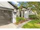 Landscaped front yard and covered entryway featuring contrasting black and white accents and a two-car garage at 3709 W Horatio St, Tampa, FL 33609