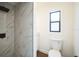 Bright bathroom featuring a tiled shower with a rainfall showerhead and a modern toilet at 3710 W Griflow St, Tampa, FL 33629