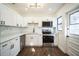 Updated kitchen with white cabinets, stainless steel appliances, modern backsplash and dark hardware at 3710 W Griflow St, Tampa, FL 33629