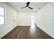 Bright living room features wood-look flooring, neutral paint, a ceiling fan, and a white front door at 3710 W Griflow St, Tampa, FL 33629