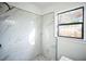 Modern tiled shower with black trim and a rainfall showerhead in a bright bathroom at 3710 W Griflow St, Tampa, FL 33629