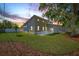 Backyard view featuring a well-maintained lawn and modern exterior of the house with a newly installed fence at 3860 Whiting Se Dr, St Petersburg, FL 33705