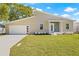 Charming house with a spacious lawn, large garage, and a well-lit front entrance at 3860 Whiting Se Dr, St Petersburg, FL 33705